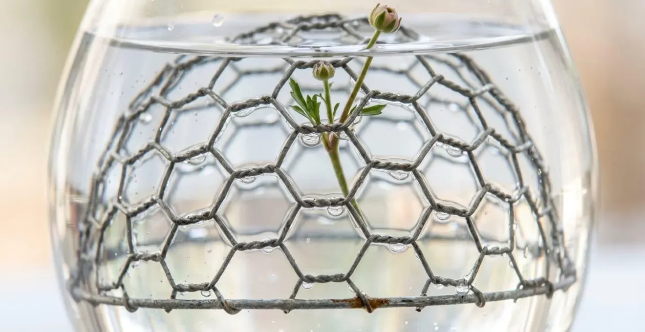 Close-up macro detail of chicken wire creating an invisible structural matrix with air pockets in clear glass vase