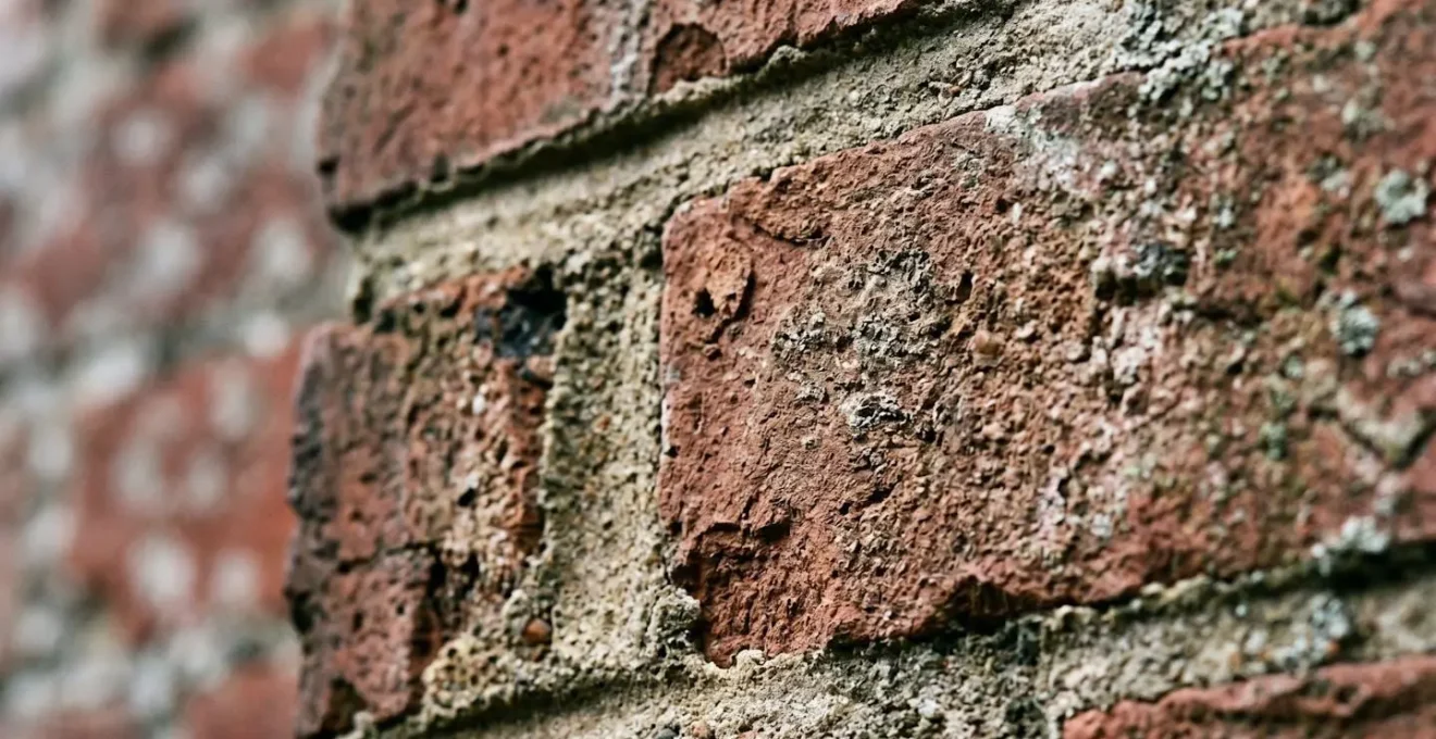 Close-up of hammer drill and masonry bit preparing mortar joint for window box installation
